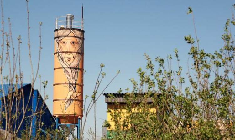 Bearded man painted on water tower by graffiti artist Nikita Nomerz