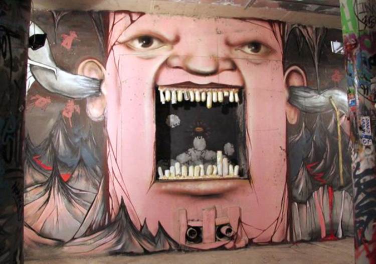 Street art face with broken teeth painted by Nikita Nomerz