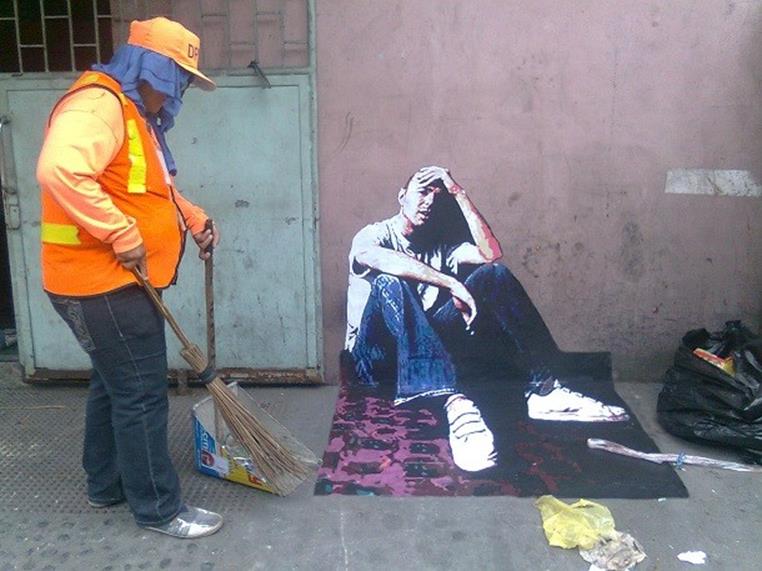 man and garbage collector street art
