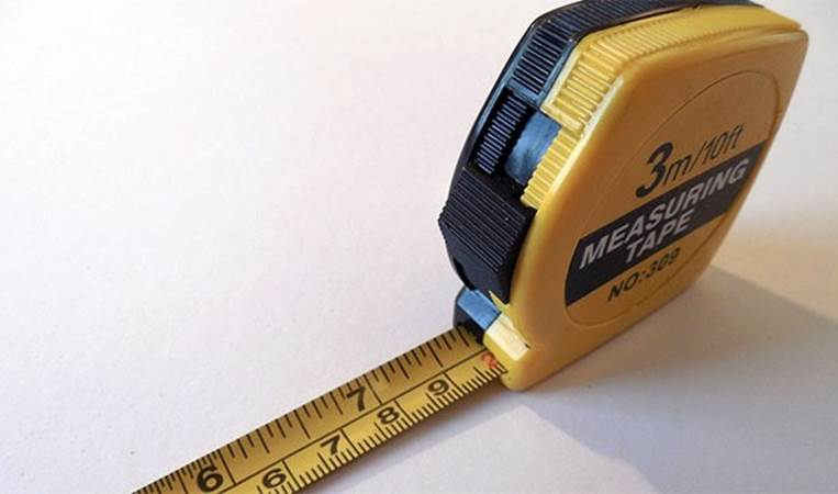 The metal notch on the end of the tape measure fits into the rut on a nail head. This is so that you can pound in a nail and make measurements by yourself.